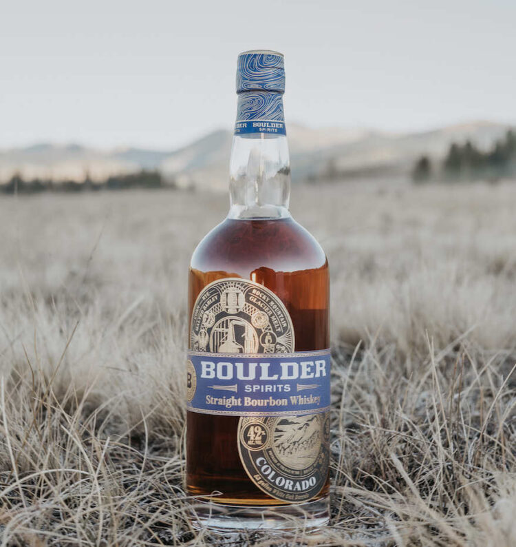 Whiskey-Flasche steht in Graslandschaft