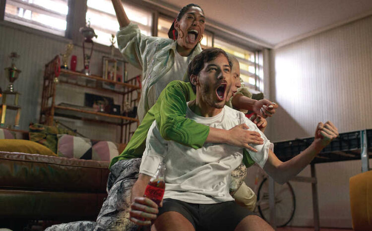 Fußball-Fans mit Coke vor dem Fernseher