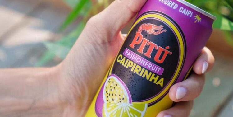 Eine Dose Pitú Passionfruit Caipirinha in einer Frauenhand