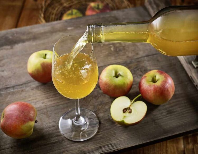 Apfelwein wird in ein Glas eingeschenkt
