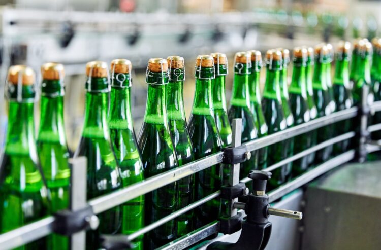 Sektflasche auf einem Förderband