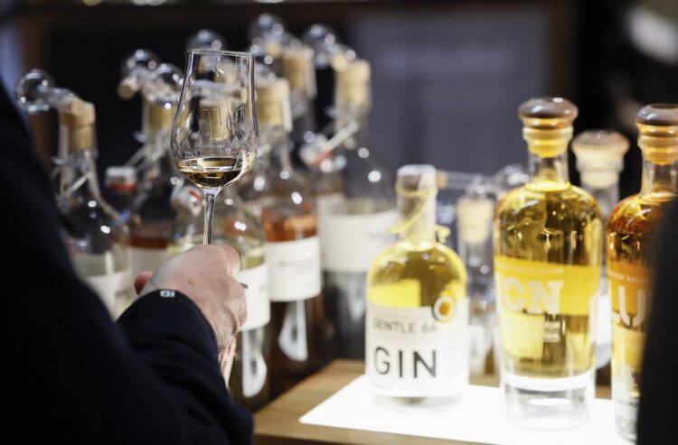 Mann verkostet Spirituosen an einem Messestand.