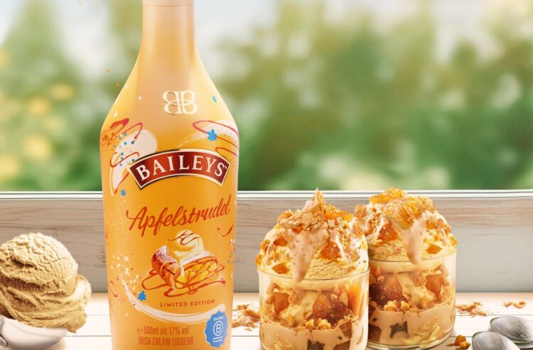 eine Flasche Baileys Apfelstrudel, dekoriert zusammen mit zwei Dessertschalen und einer Kugel Eis
