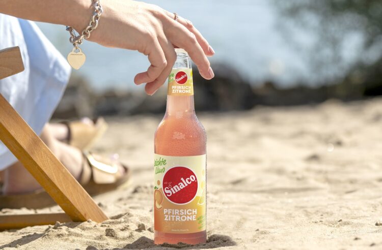 Frau am Strand mit einer Flasche Sinalco Leichte Limo in der Longneckflasche