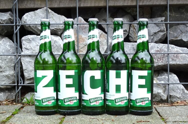 Fünf Bierflaschen, die das Wort "Zeche" bilden