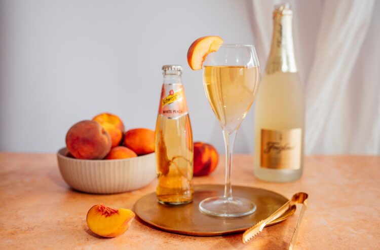 Freixenet und Schweppes mit Pfirsichen auf einem Tisch