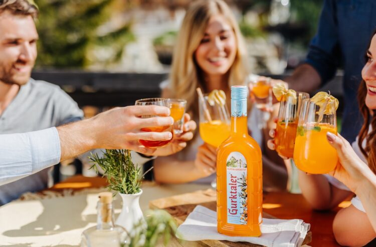Junge Leute stoßen mit Gurktaler Alpen-Aperitif an