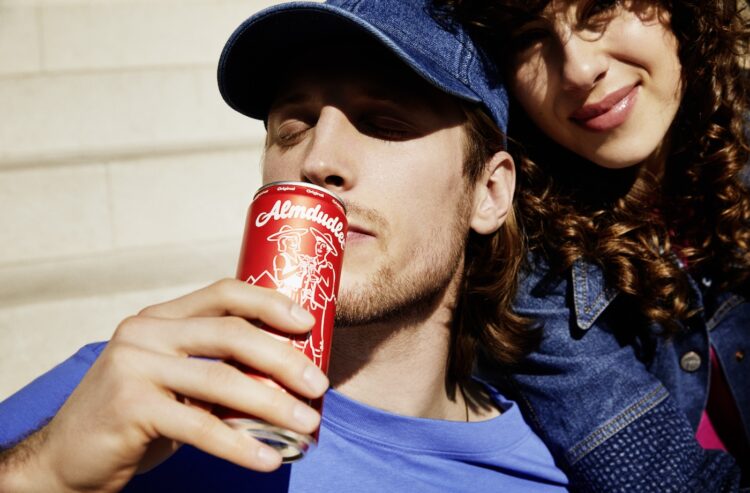 Junger Mann trinkt aus Almdudler-Dose.