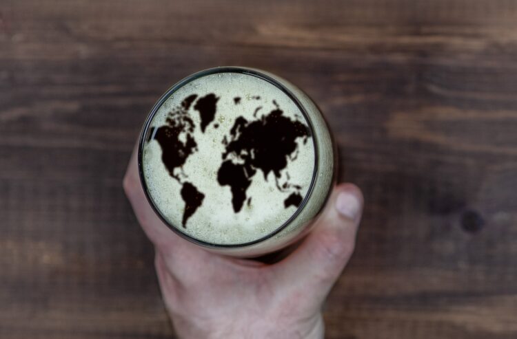 Foto Bierglas mit Schaum, in dem die Weltkarte zu sehen ist