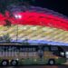 Bus mit Bitburger-Schriftzug vor beleuchtetem EM-Stadion