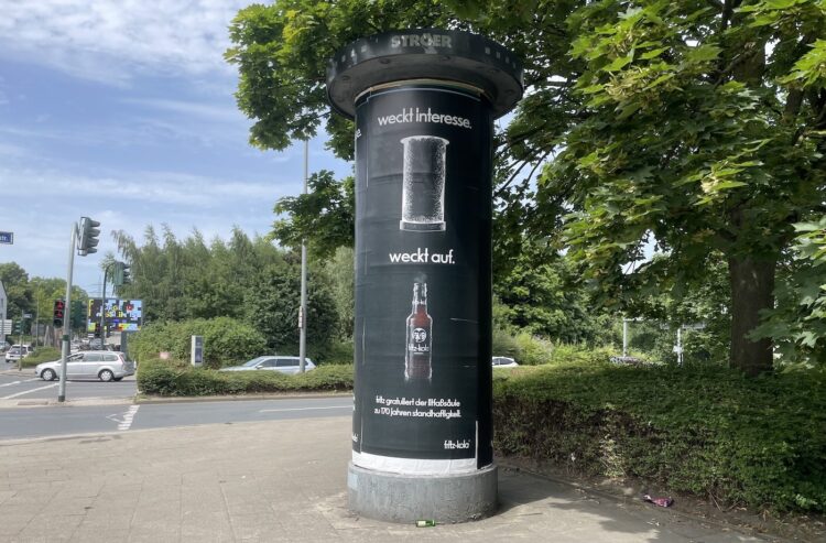 Litfaßsäule mit Fritz-Kola-Werbung an einer Straßenkreuzung