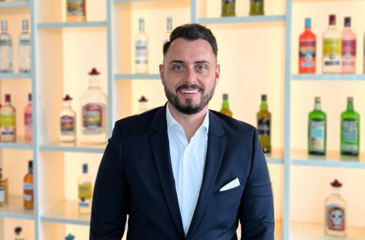 Porträt Silas Haas vor Spirituosenregal