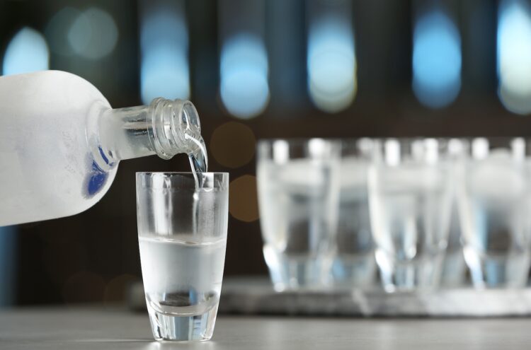 Wodka wird aus einer Flasche in ein Glas gegossen