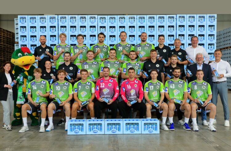 Handballmannschaft vor einer Wand aus Salvus-Kisten