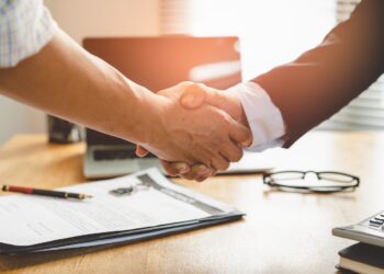 Nahaufnahme Händeschütteln vor Bürohintergrund