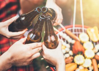 Bierflaschen und Grill im Hintergrund