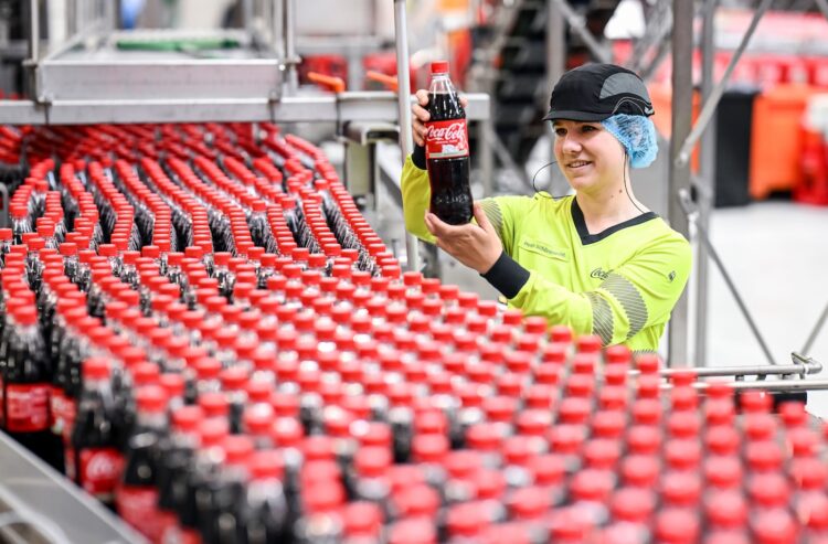 Arbeiterin an einer Abfülllinie für Coca-Cola