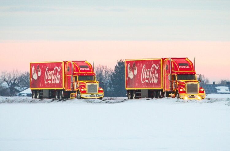 Zwei Coca-Cola Trucks in Winterlandschaft