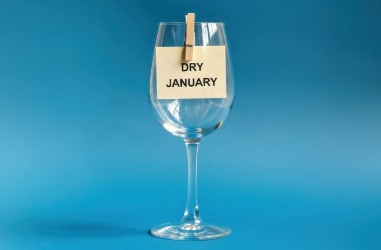 Leeres Weinglas mit angeklammertem Zettel "Dry January"