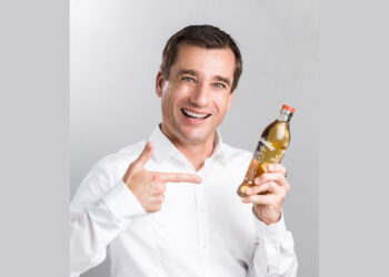 Porträt Mike Mühlberger mit Almdudler-Flasche